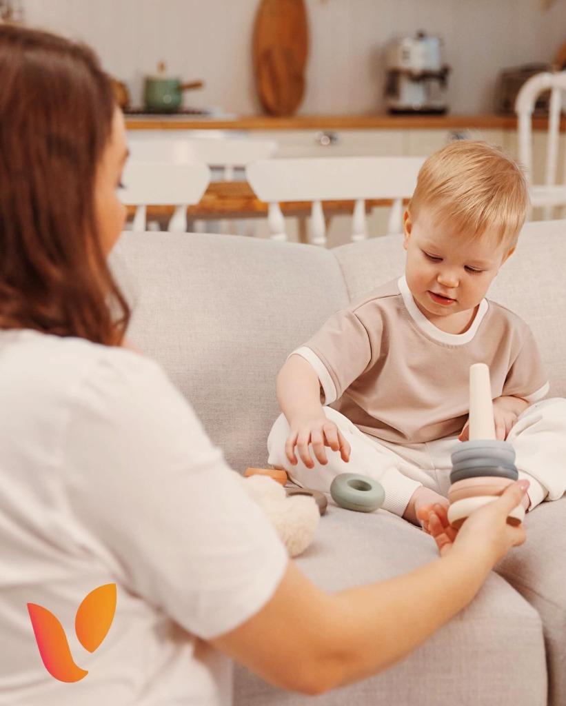 Caregiver smiling and playing with toddler